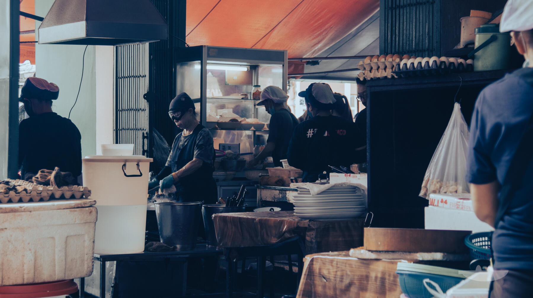 Jay Fai cooking with her googles on at the wok outside on the street